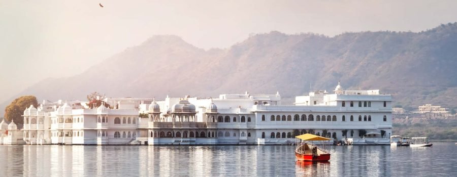 White palace and boat on Lake Pichola in Udaipur, Rajasthan, India
